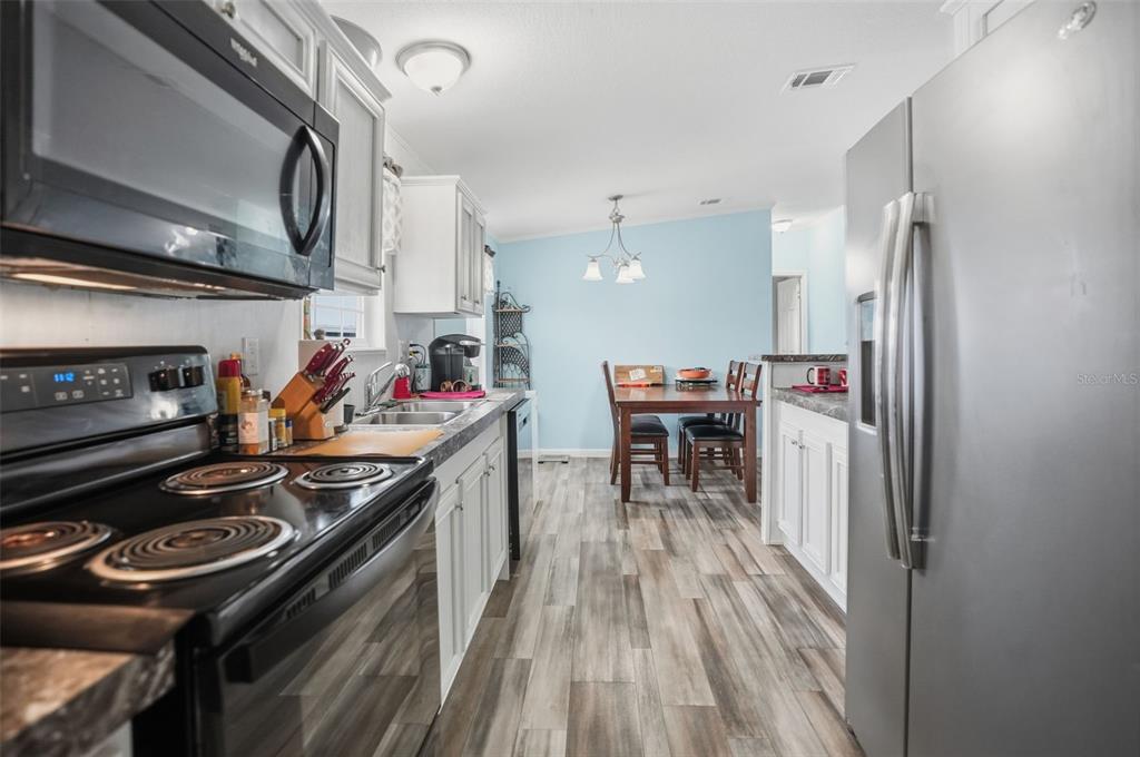 9100 Highpoint Boulevard Brooksville, FL 34613 - Photo 8 of 42 a kitchen with stainless steel appliances granite countertop a stove and a refrigerator