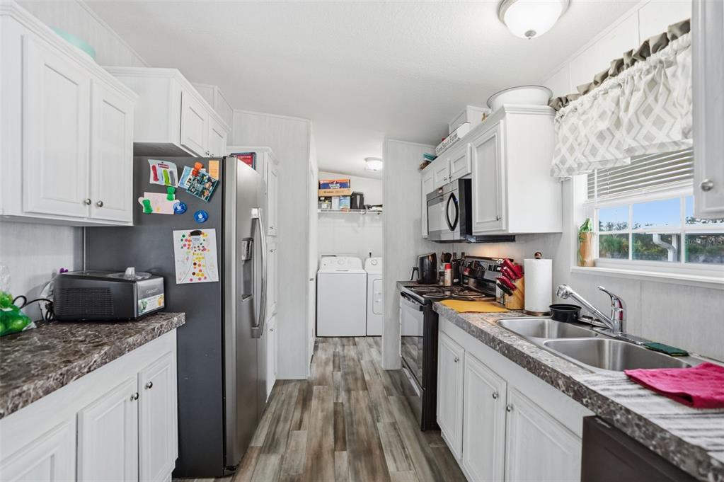 9100 Highpoint Boulevard Brooksville, FL 34613 - Photo 9 of 42 a kitchen with granite countertop a refrigerator stove top oven and sink