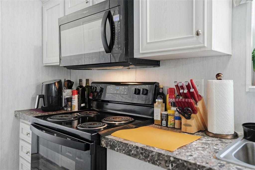 9100 Highpoint Boulevard Brooksville, FL 34613 - Photo 10 of 42 a kitchen with stainless steel appliances granite countertop a stove and a microwave