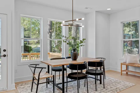 a dining room with furniture a chandelier and wooden floor