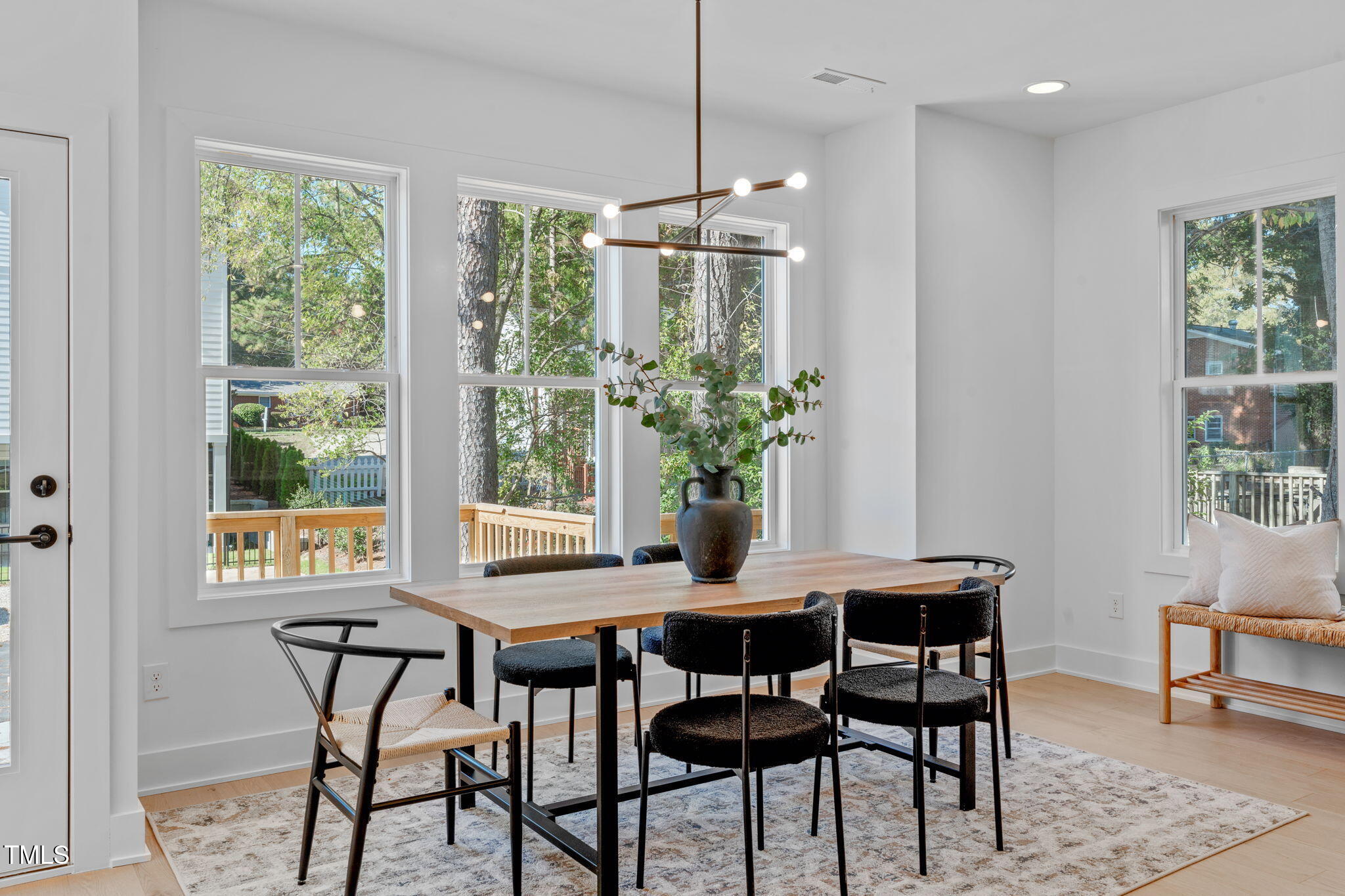 5061 Lundy Drive, Unit 101 Raleigh, NC 27606 - Photo 12 of 56 a dining room with furniture a chandelier and wooden floor