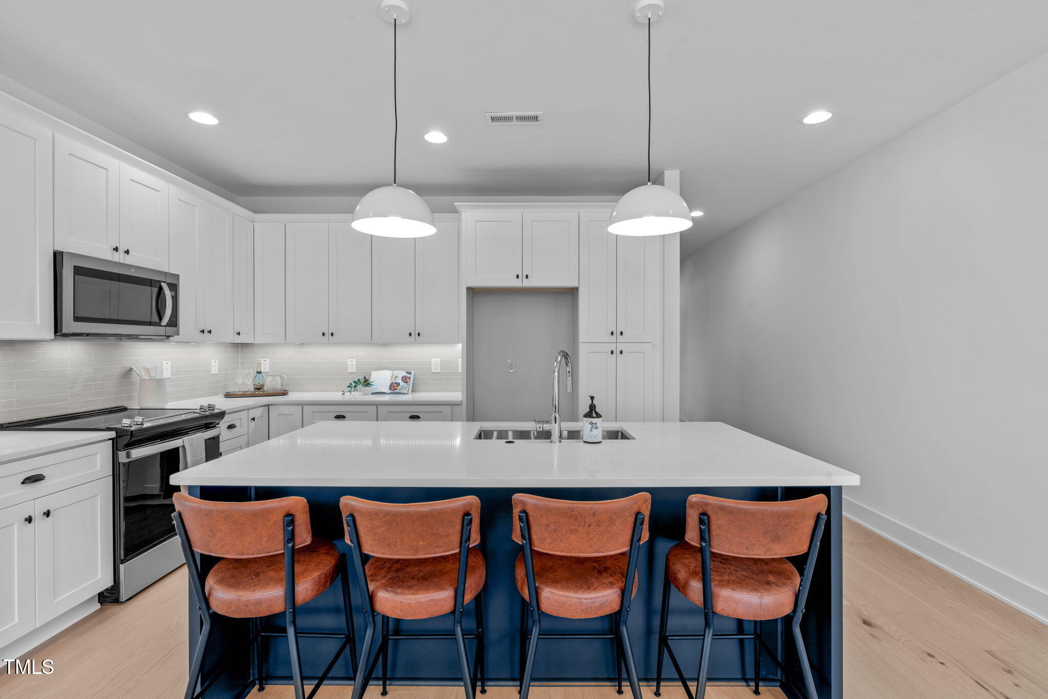 5061 Lundy Drive, Unit 101 Raleigh, NC 27606 - Photo 7 of 56 a kitchen with a dining table chairs and white cabinets