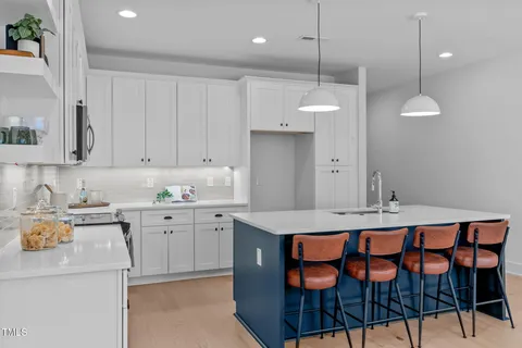 a kitchen that has a cabinets and chairs in it
