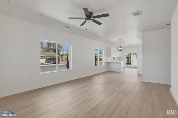 an empty room with a window and a ceiling fan