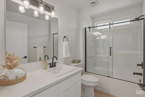 a spacious bathroom with a sink a shower and a mirror