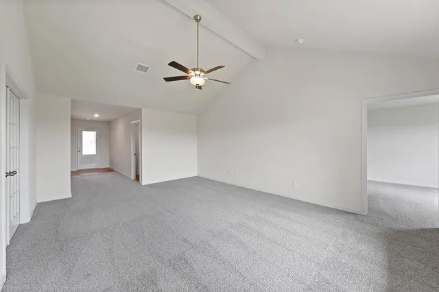an empty room with a ceiling fan and a window