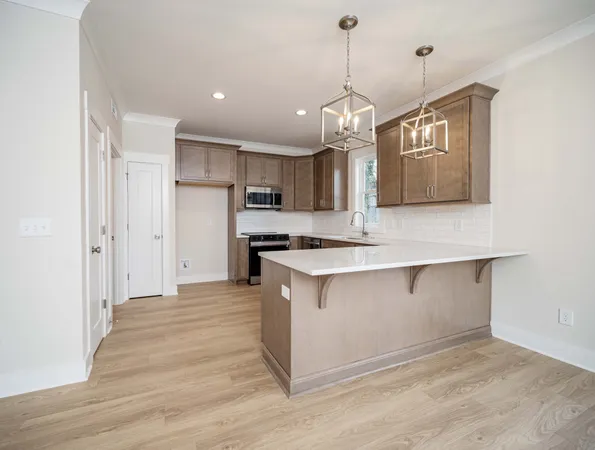 a large kitchen with stainless steel appliances granite countertop a sink a refrigerator and a stove