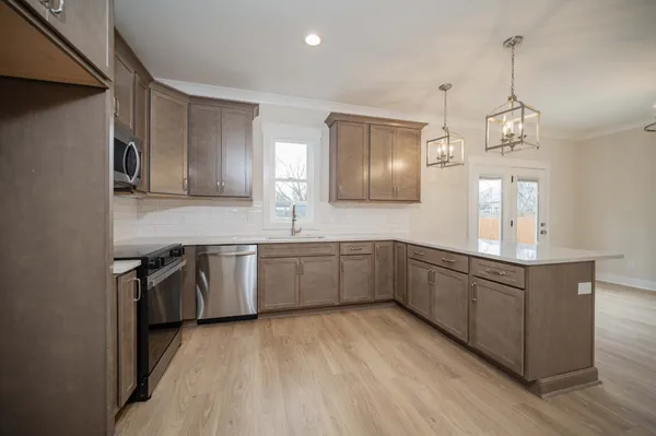 a kitchen with granite countertop a sink cabinets and stainless steel appliances