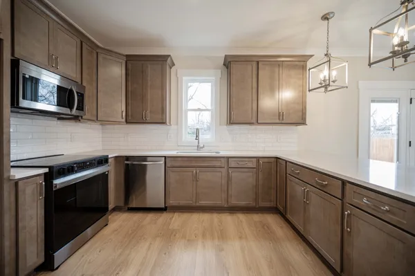 a kitchen with stainless steel appliances granite countertop a sink and microwave