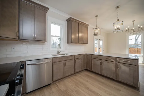 a kitchen with stainless steel appliances granite countertop wooden cabinets a sink and dishwasher