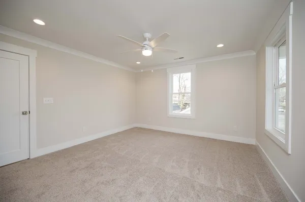 en empty room with windows and chandelier fan