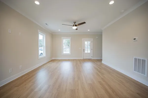 an empty room with wooden floor and windows