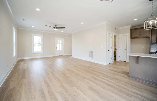 an empty room with wooden floor and windows