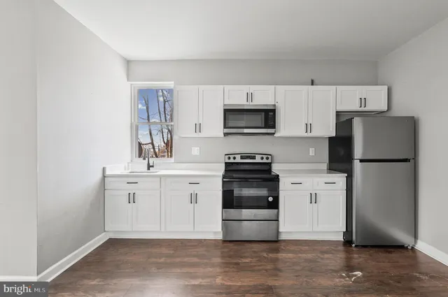 a kitchen with white cabinets and stainless steel appliances