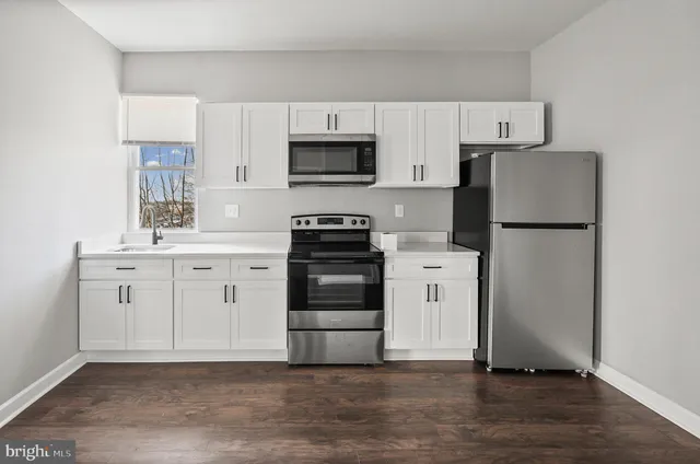 a kitchen with white cabinets and stainless steel appliances