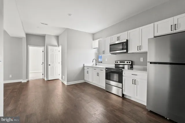 a kitchen with a refrigerator stove and white cabinets