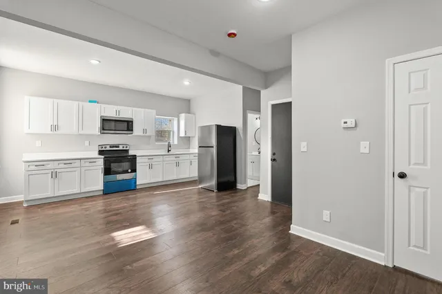 a view of a kitchen with wooden floor and electronic appliances