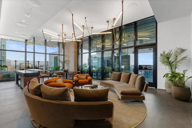 a living room with furniture a floor to ceiling window and potted plants