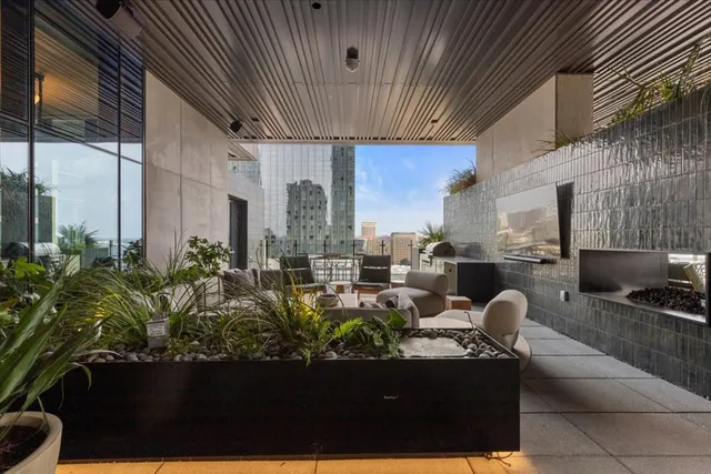 a living room with couches a coffee table and with potted plants