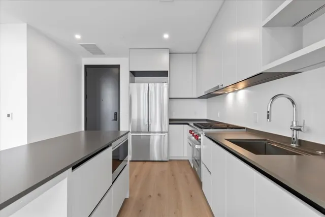 a kitchen with granite countertop a sink and a refrigerator