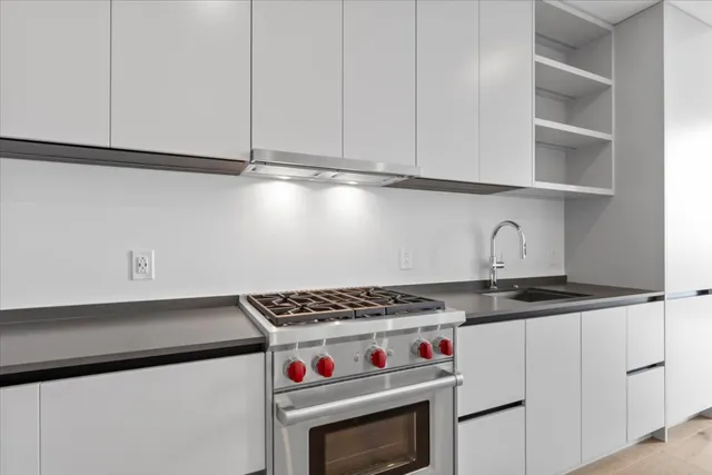 a kitchen with granite countertop a stove and a sink