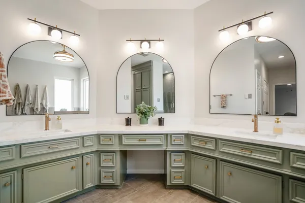 a bathroom with double vanity and a mirror