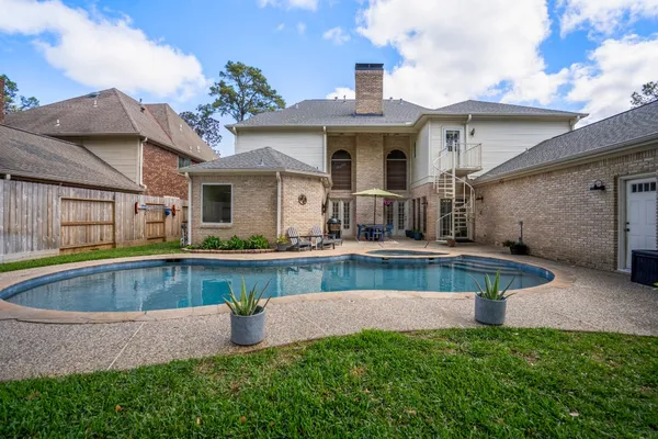 a view of a house with pool fire pit and chairs in the patio