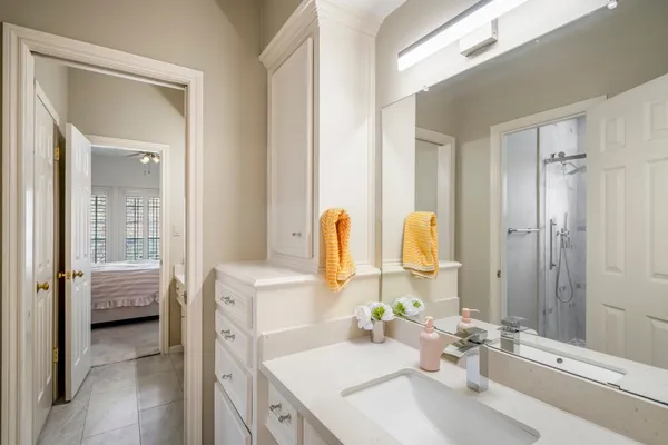 a en suite bathroom with a granite countertop sink and a mirror
