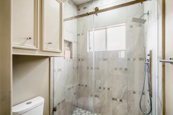 a bathroom with a shower toilet and sink