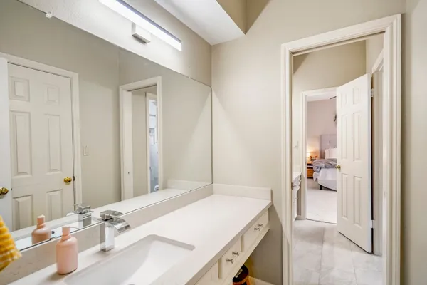 a en suite bathroom with a granite countertop sink and a mirror