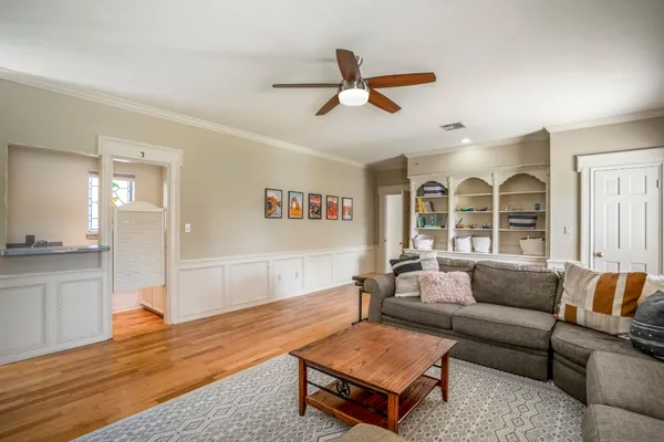 a living room with furniture and a wooden floor