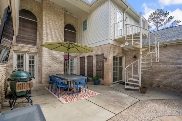 a view of a patio with a table and chairs under an umbrella