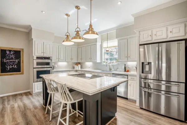 a kitchen with kitchen island a wooden floor and white appliances
