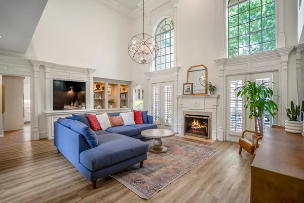 a living room with furniture a fireplace and a large window