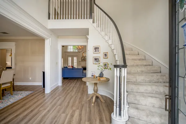 a view of a hallway with wooden floor and staircase