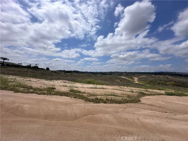 a view of a dry yard with wooden fence