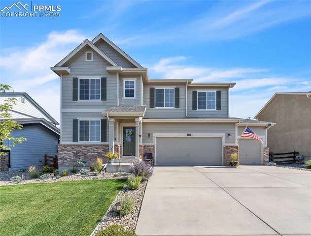 a front view of a house with a garden and yard