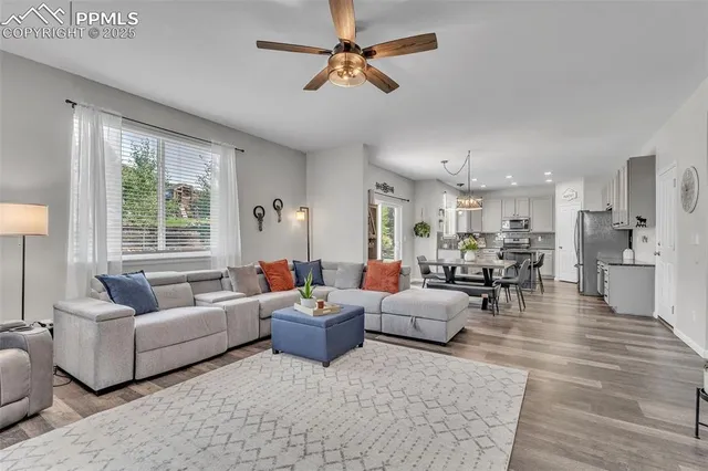 a living room with furniture ceiling fan and a window