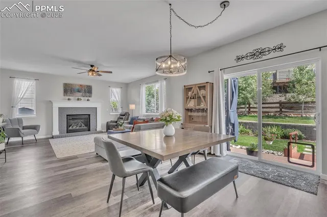 a dining room with wooden floor a chandelier a wooden table and chairs