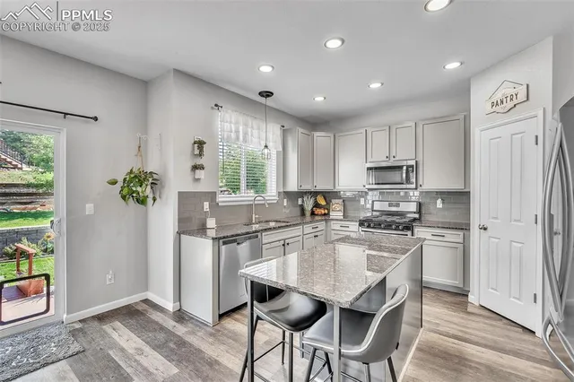 a kitchen with stainless steel appliances granite countertop sink refrigerator and microwave