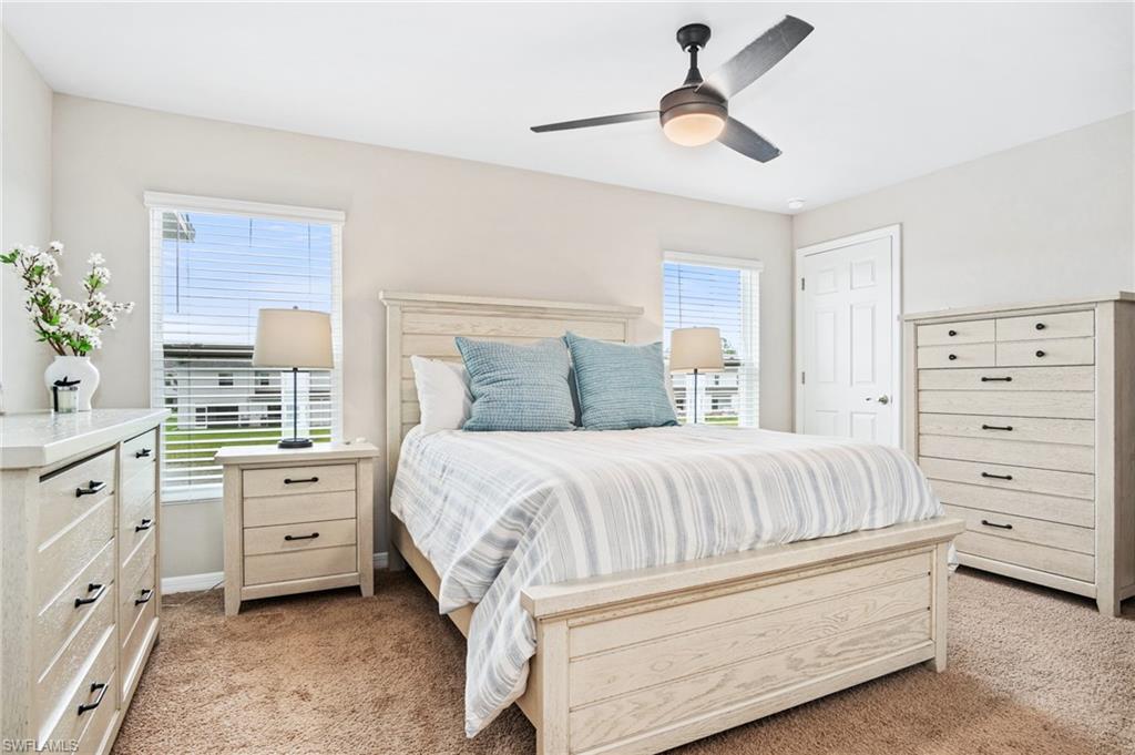 15070 Wildflower Circle Naples, FL 34119 - Photo 16 of 22 a bedroom with a bed and a chandelier