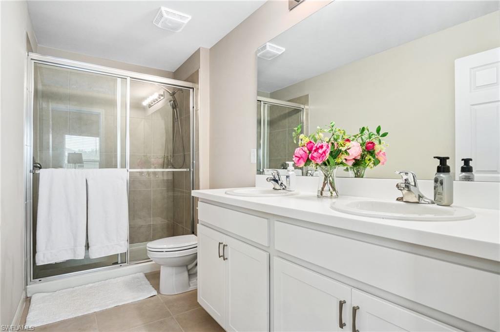 15070 Wildflower Circle Naples, FL 34119 - Photo 17 of 22 a bathroom with a sink vanity mirror and toilet