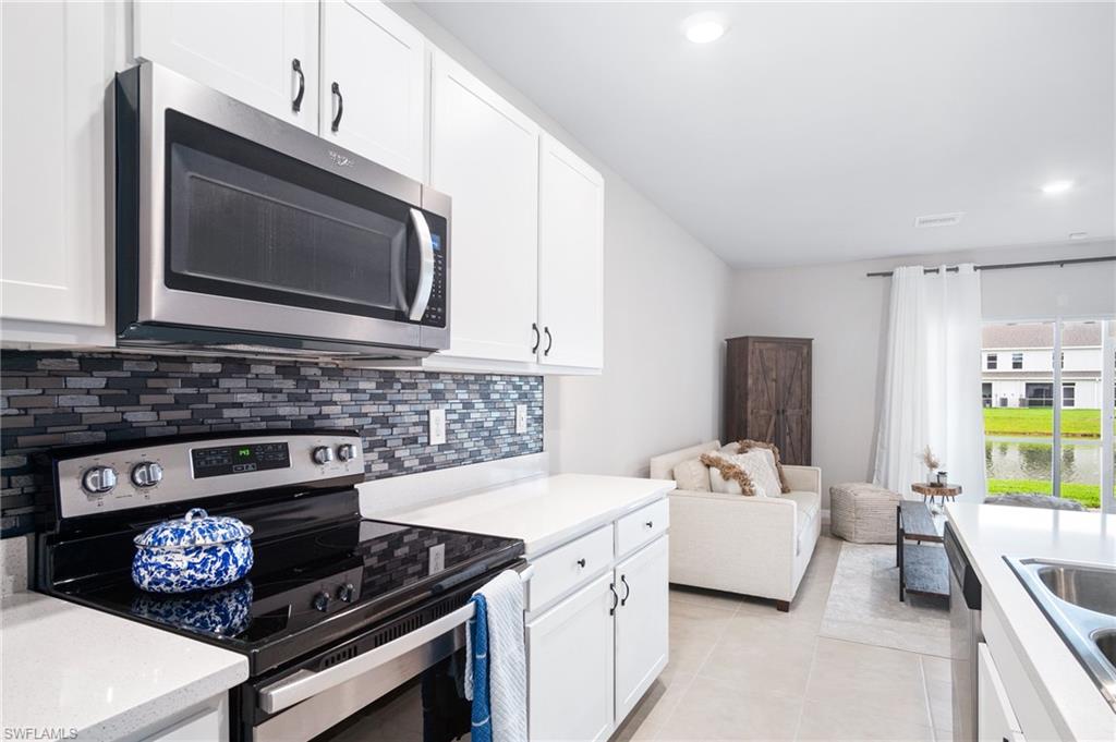 15070 Wildflower Circle Naples, FL 34119 - Photo 4 of 22 a kitchen with a stove and a microwave