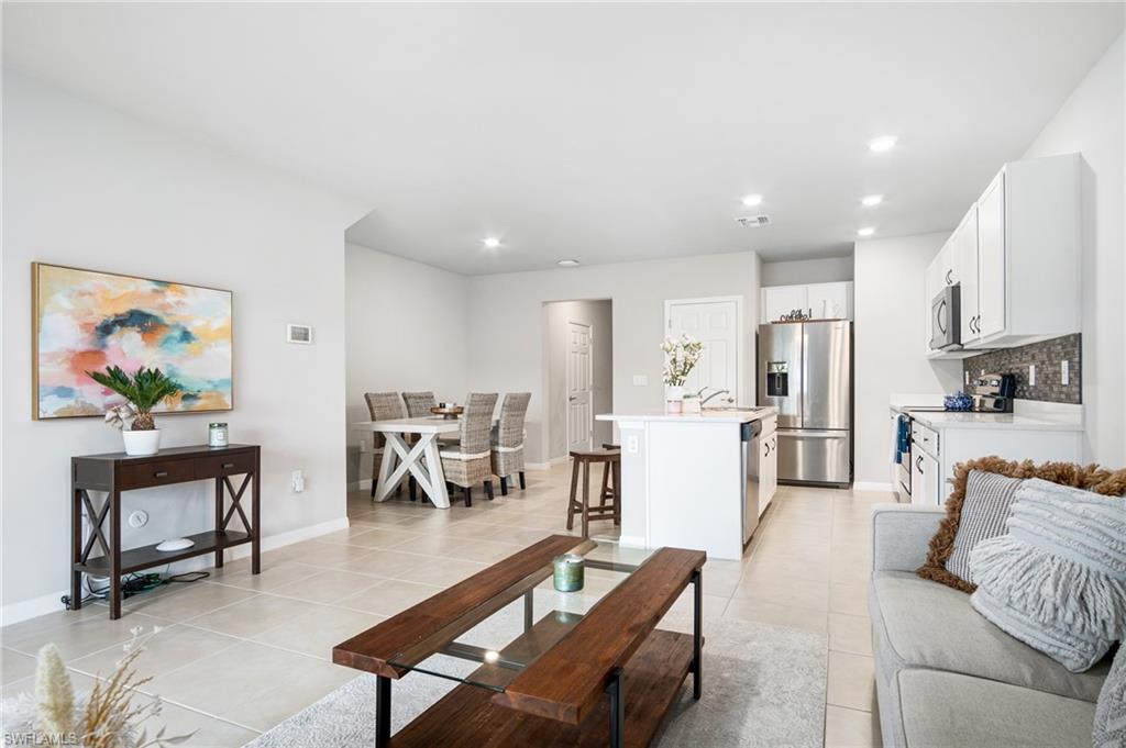 15070 Wildflower Circle Naples, FL 34119 - Photo 10 of 22 a living room with furniture a kitchen view and a dining table