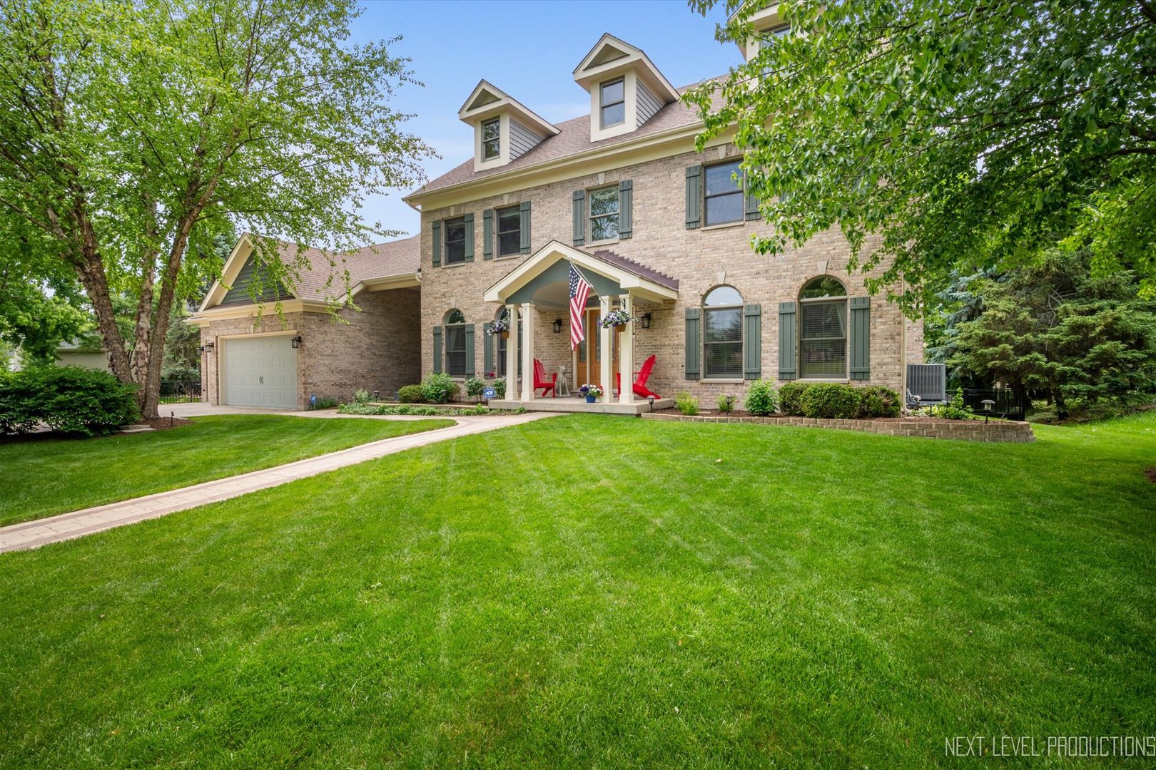 a front view of a house with a garden and trees