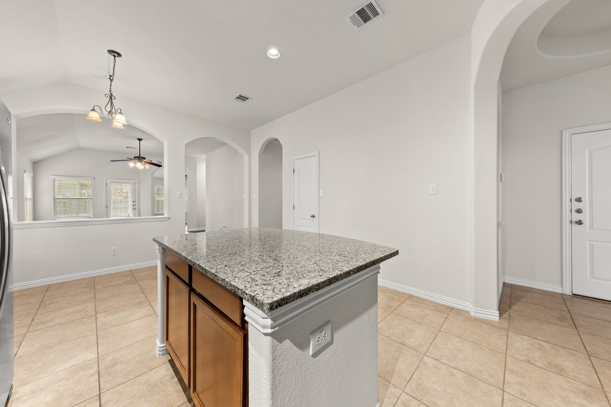 411 Tascate Street Georgetown, TX 78628 - Photo 9 of 41 A central island with granite counters defines this open-concept kitchen.