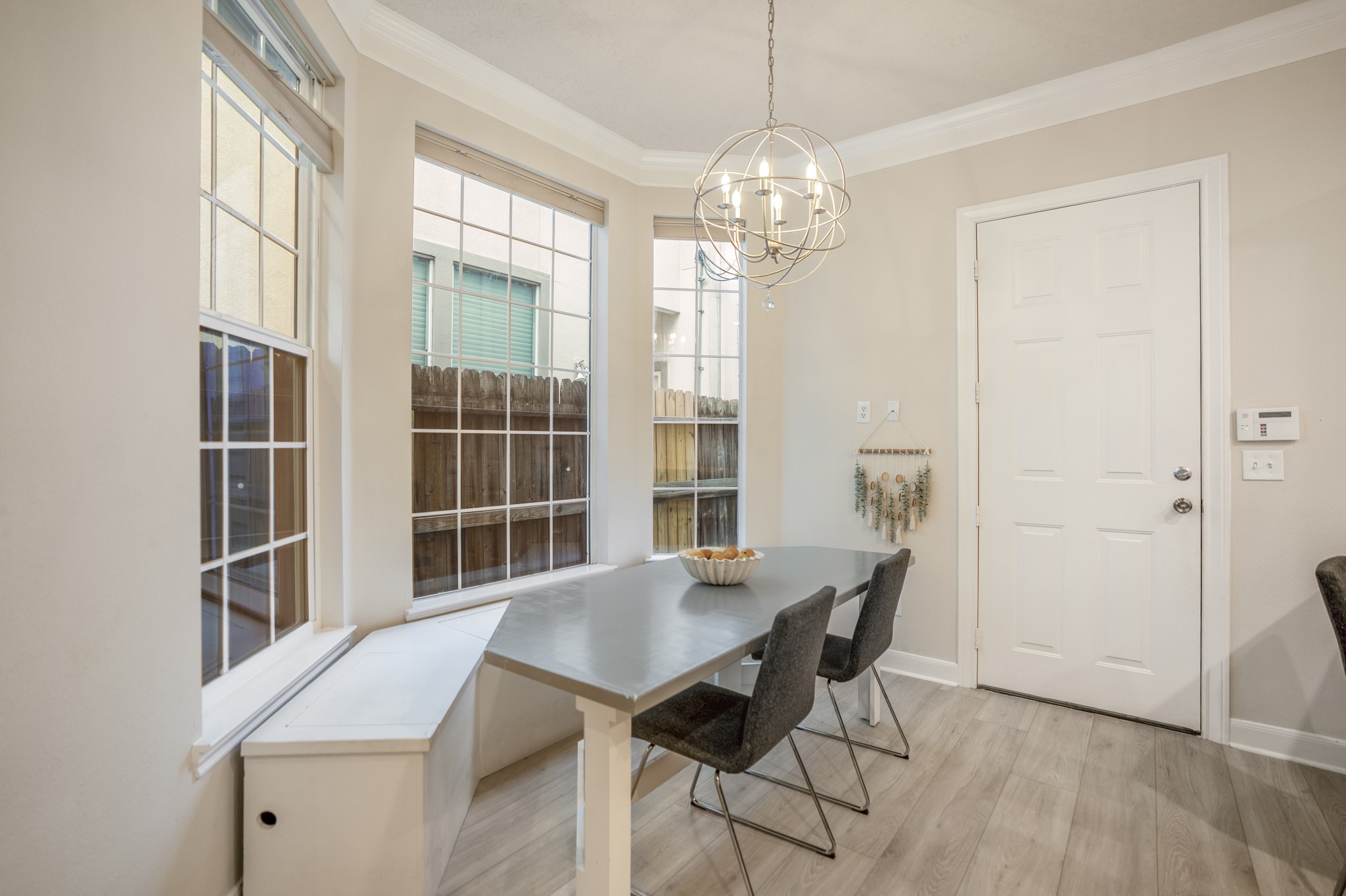4236 Drake Street Houston, TX 77005 - Photo 10 of 43 The sunlit breakfast area with expansive windows and stylish designer lighting was updated in 2024 with a custom bench and table build out.