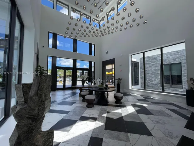 a front view of multi story residential apartment building with yard and sign board