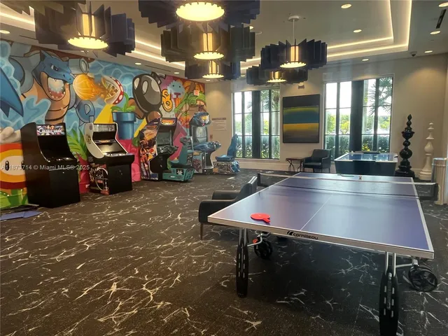 a view of a very nice looking living room with a large window and potted plants