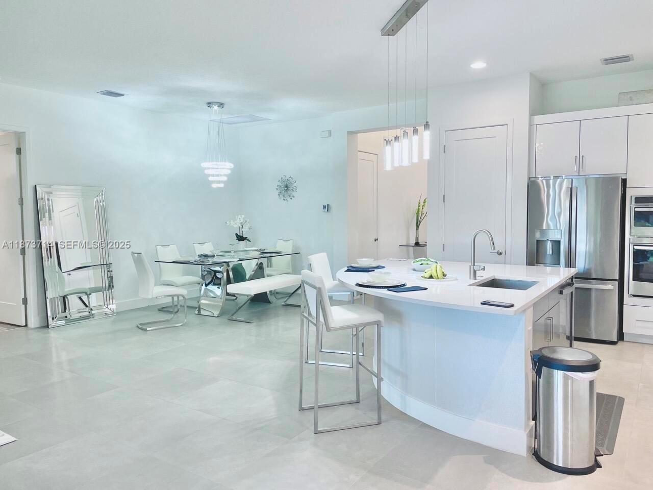 17267 Windy Pointe Lane Boca Raton, FL 33496 - Photo 6 of 47 a room with stainless steel appliances kitchen island furniture and a view of living room